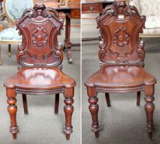 A Pair of 19th century Mahogany Shield Back Hall Chairs, with foliate scroll carving, central
