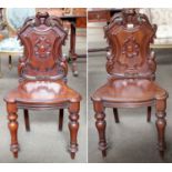 A Pair of 19th century Mahogany Shield Back Hall Chairs, with foliate scroll carving, central