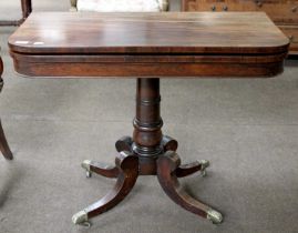 A Regency Rosewood Fold Over Card Table with green baize inset, raised on turned column to four