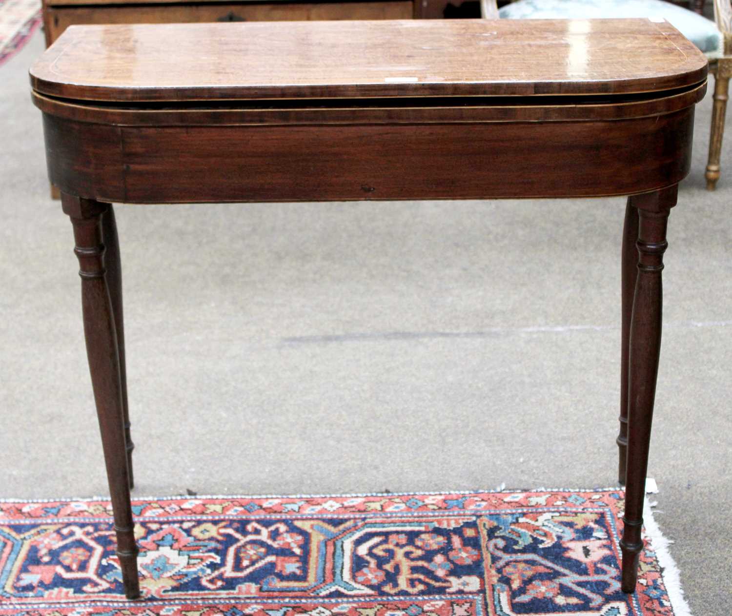 An Early 19th century Mahogany Fold Over Tea Table, raised on slender turned legs, 75cm by 86cm by