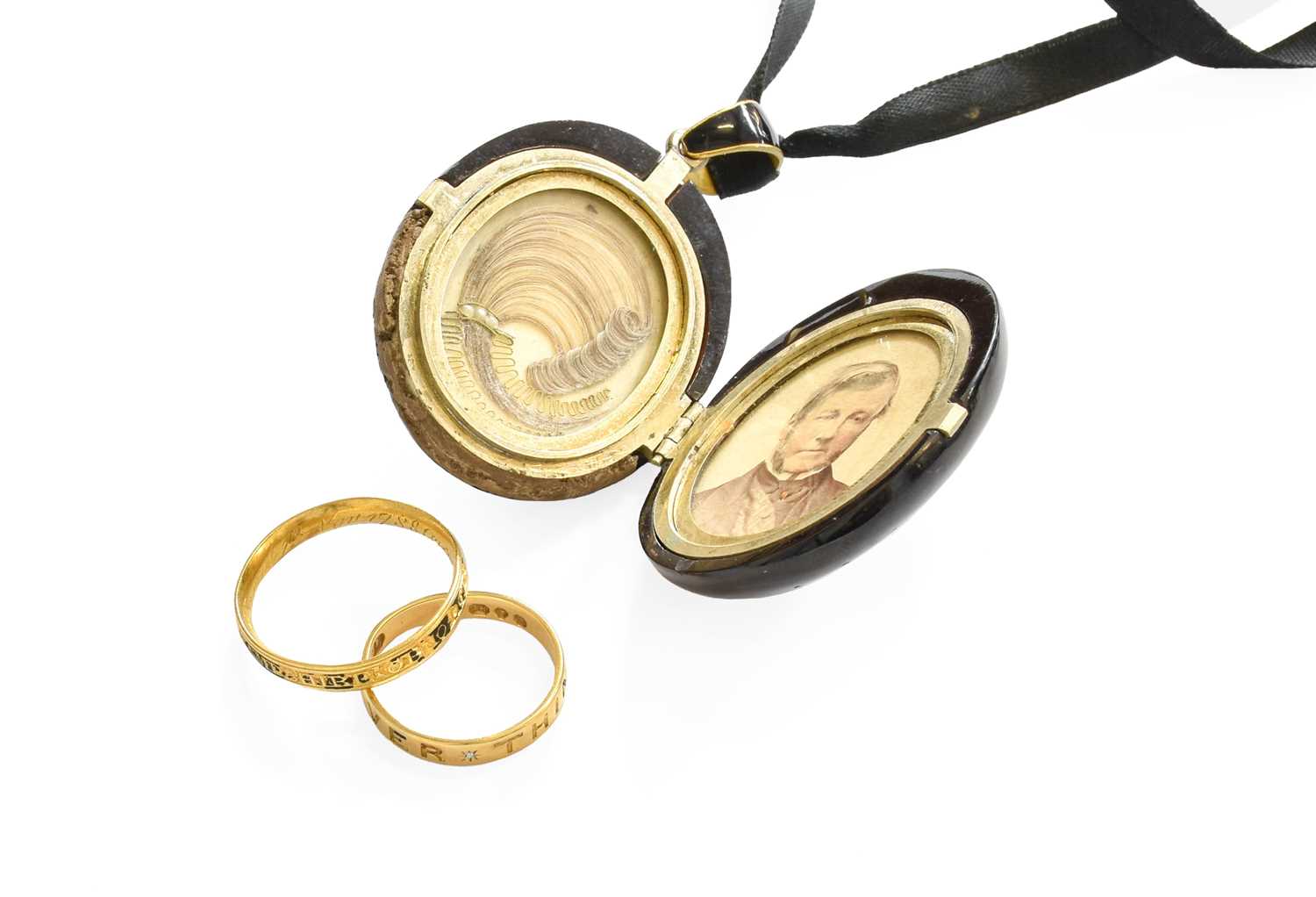 A Jet Mourning Locket, the locket carved with foliate decoration within a Greek Key border,