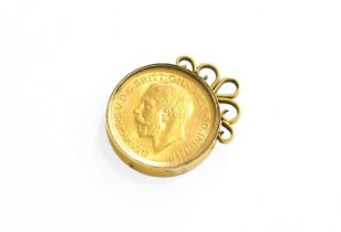 A Sovereign Charm, dated 1915, enclosed within a perspex cover, mount stamped '18CT', length 3.0cm