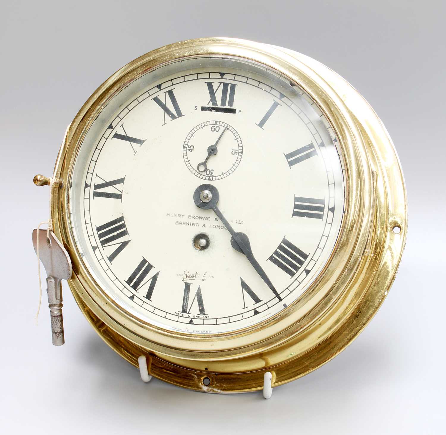 A Brass Ships Type Bulk Head Wall Timepiece, retailed by Henry Browne & Son Ltd, Barking & London