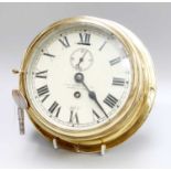 A Brass Ships Type Bulk Head Wall Timepiece, retailed by Henry Browne & Son Ltd, Barking & London