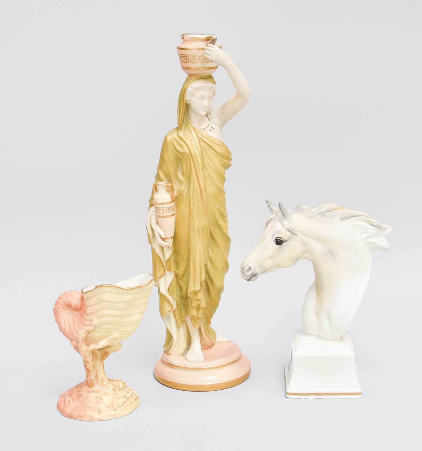 A Royal Worcester Blush Ivory Figure of a Water Carrier, 24.5cm high, a Worcester bust of a horse,