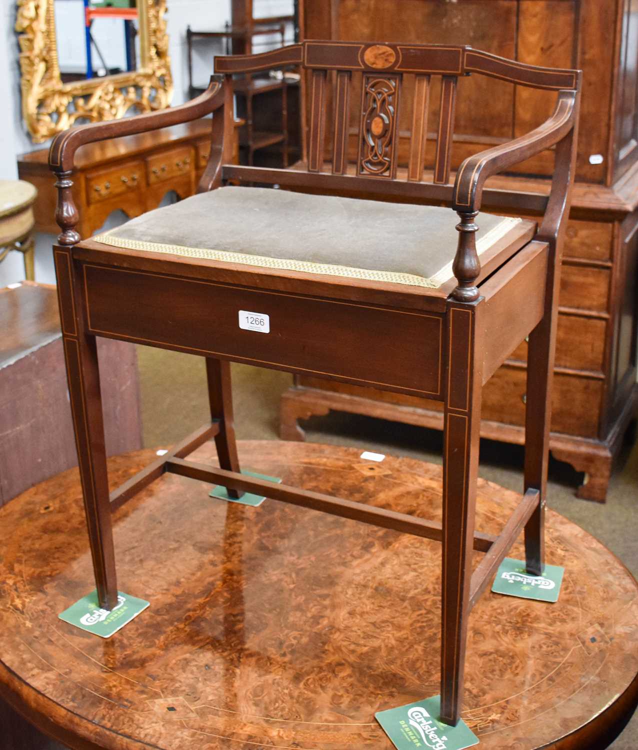 An Edwardian Mahogany and Inlaid Piano Stool, with slat back, scroll arms, hinged seat, raised on