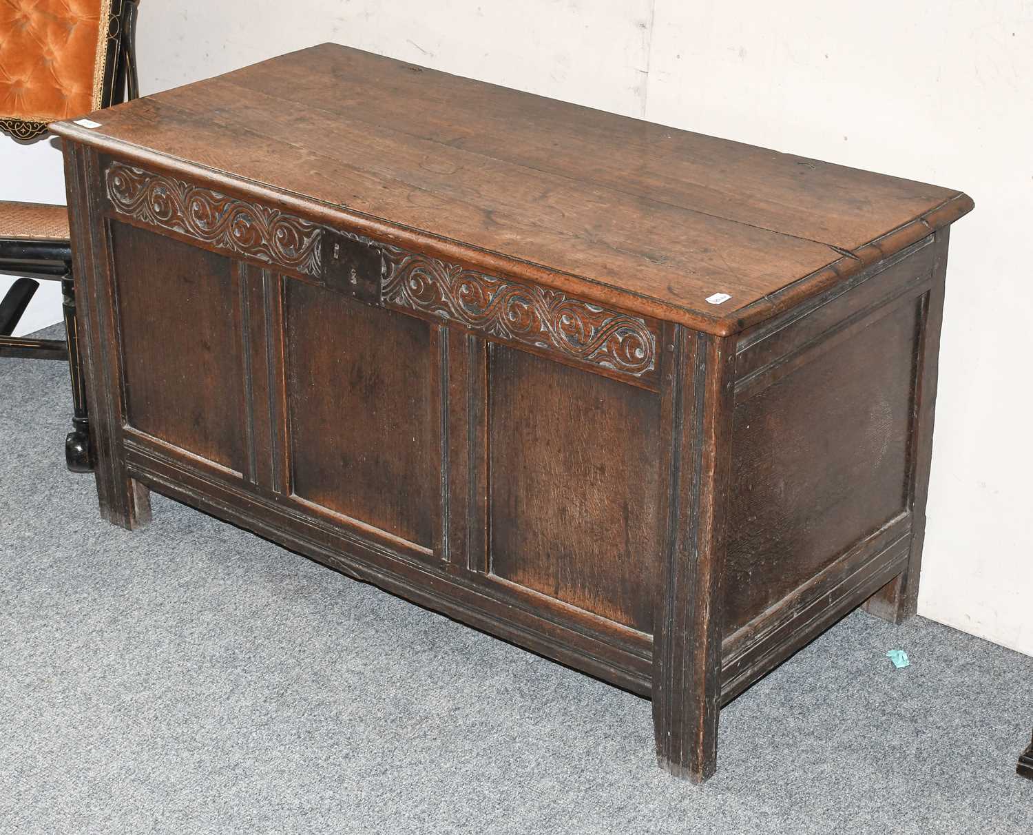 A Late 17th Century Oak Coffer, with hinged lid, carved foliate scroll frieze, on stile ends, 63cm