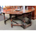 An 18th Century and Later Walnut and Oak Gateleg Table, oval top with twin drop leaves, raised on