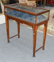 An Early 20th century Display Table, the hinged glazed top on four glazed sides, housing a lined
