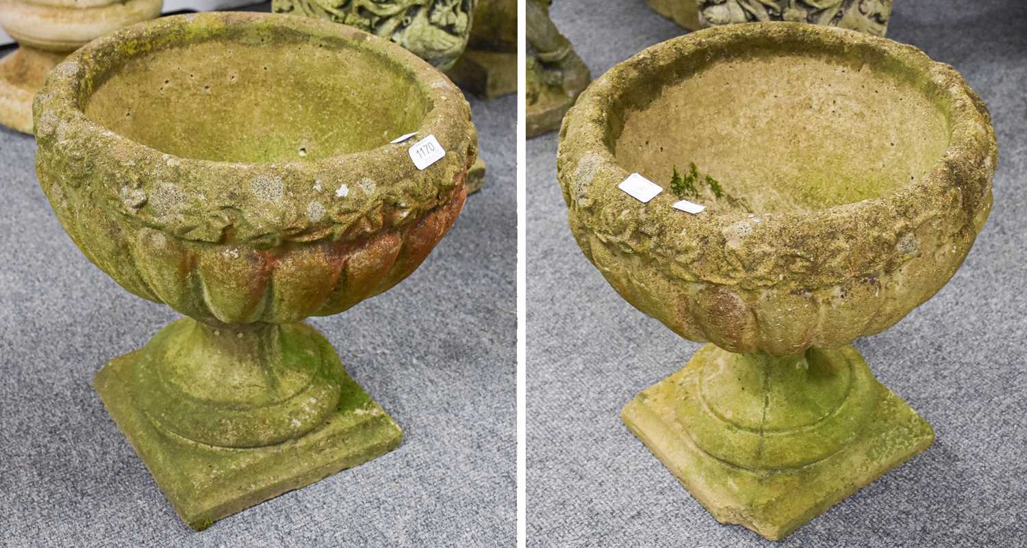 A Pair of Composition Neo-Classical Garden Urns, with relief foliate friezes, on socle plinth bases,