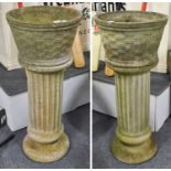 A Pair of Composite Garden Planters, basketwork effect, raised on fluted column plinths, 104cm by