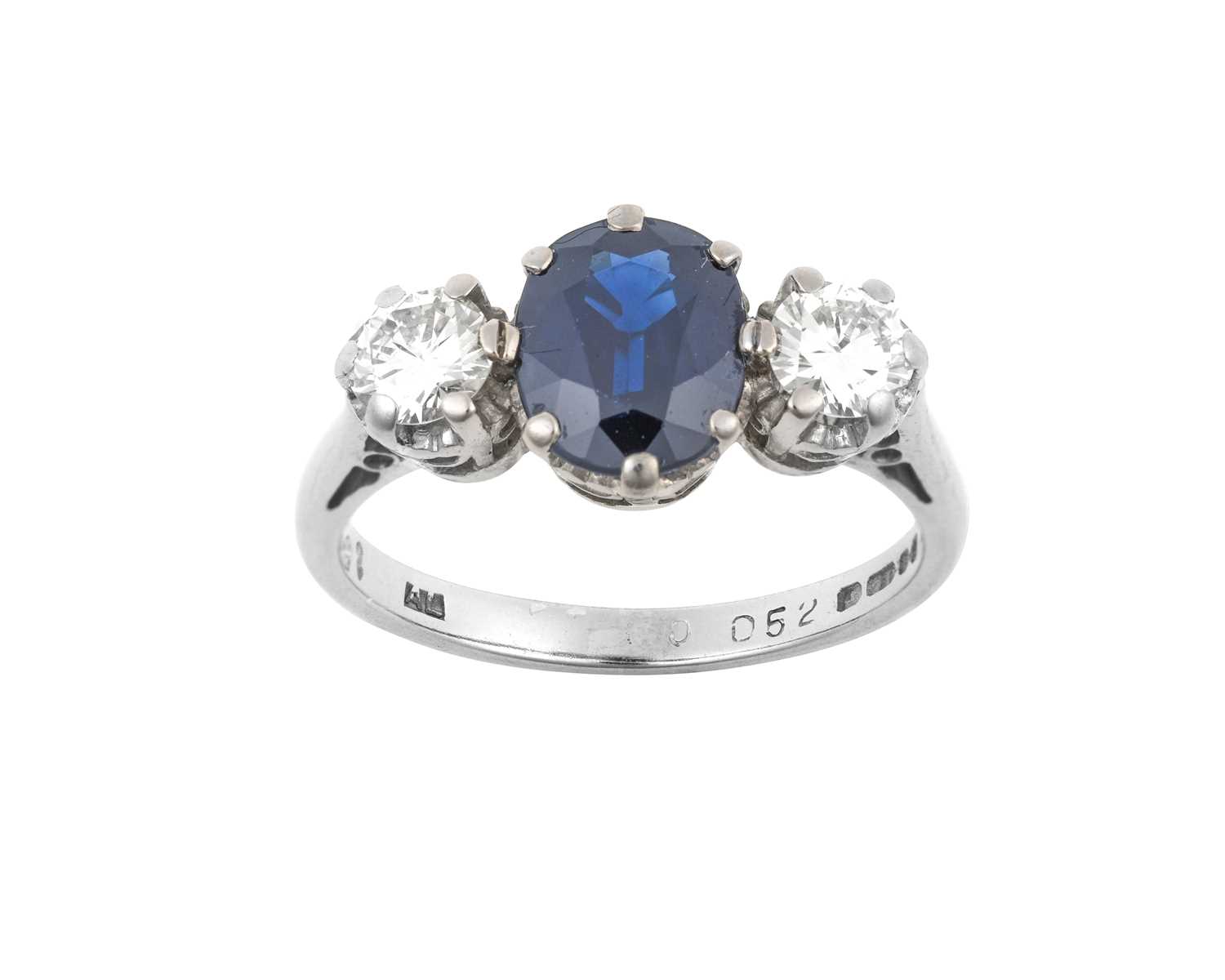 An 18 Carat White Gold Sapphire and Diamond Three Stone Ring the oval cut sapphire flanked by