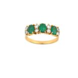 An Emerald and Diamond Ring three oval cut emeralds spaced by pairs of round brilliant cut diamonds,