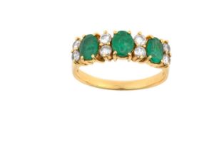 An Emerald and Diamond Ring three oval cut emeralds spaced by pairs of round brilliant cut diamonds,