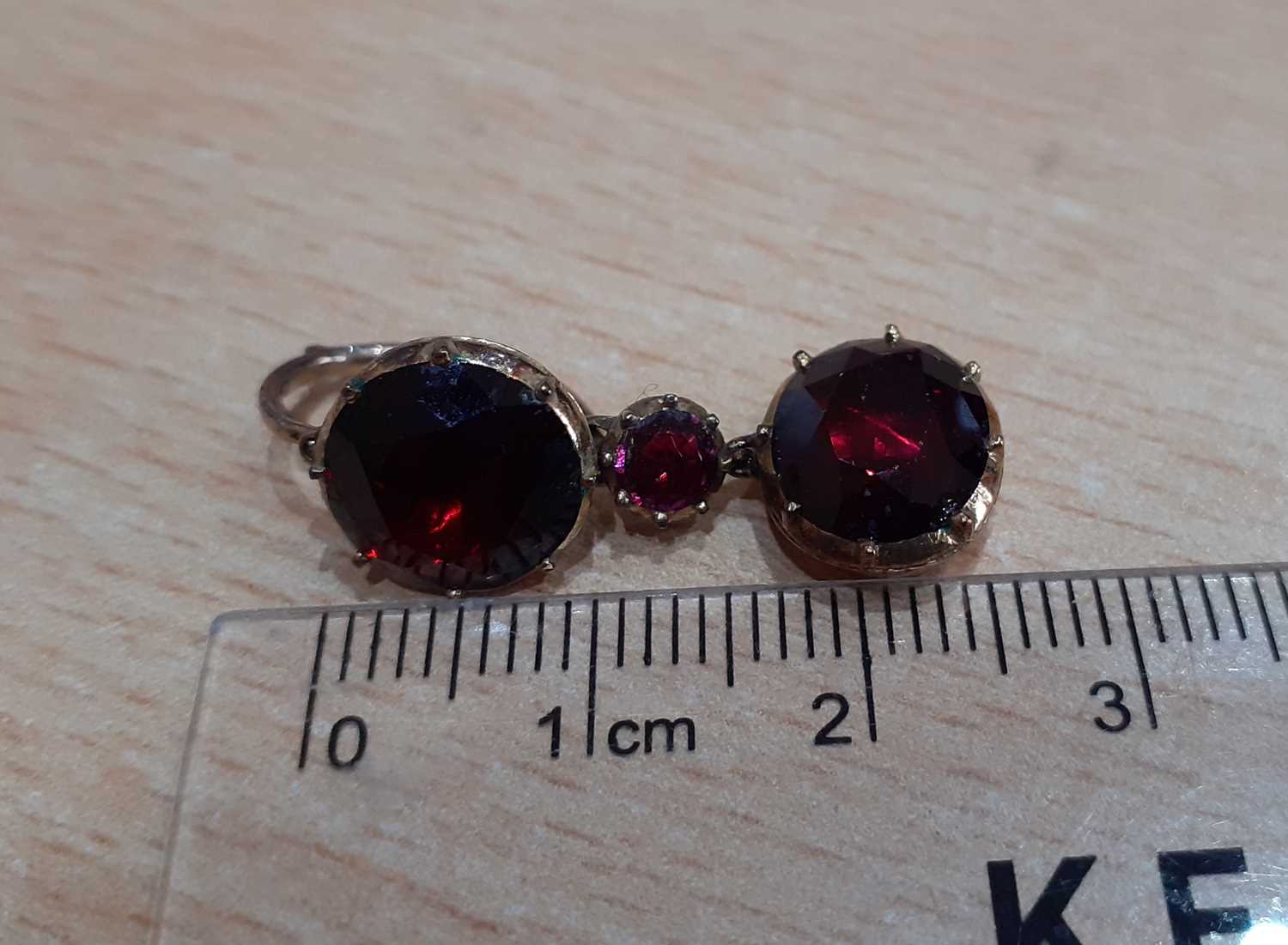 A Pair of Garnet Drop Earrings a round cut garnet suspends a smaller round cut garnet and an oval - Image 2 of 3