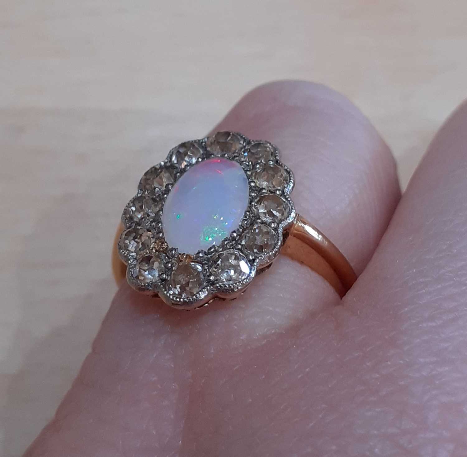 An Opal and Diamond Cluster Ring the oval opal within a border of old cut diamonds, in white - Image 4 of 5