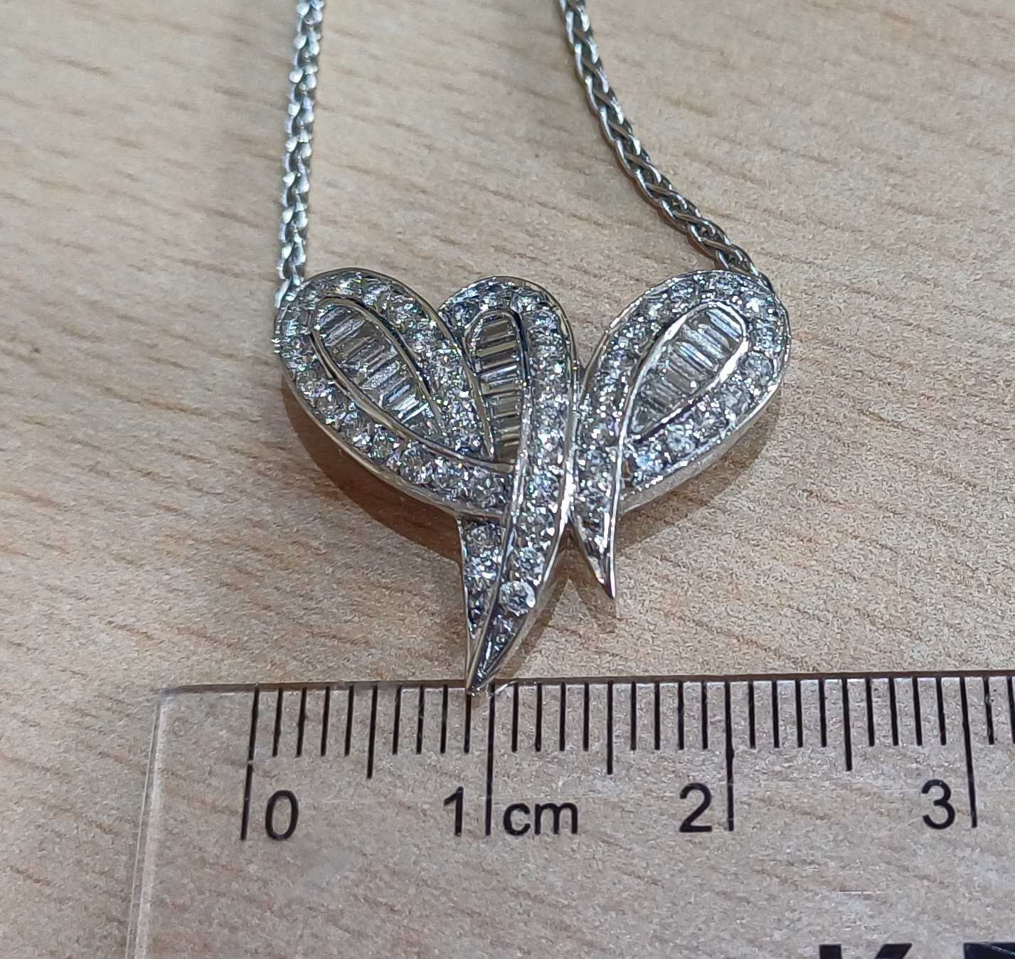 An 18 Carat Gold Diamond Pendant on Chain the stylised ribbon motif set throughout with baguette cut - Image 2 of 4