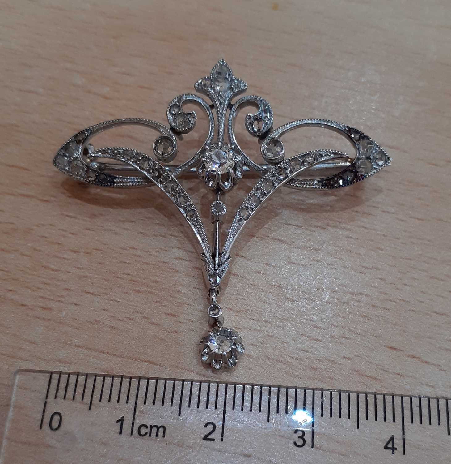 An Early 20th Century Diamond Brooch of openwork scroll form, set throughout with old cut and rose - Image 2 of 4