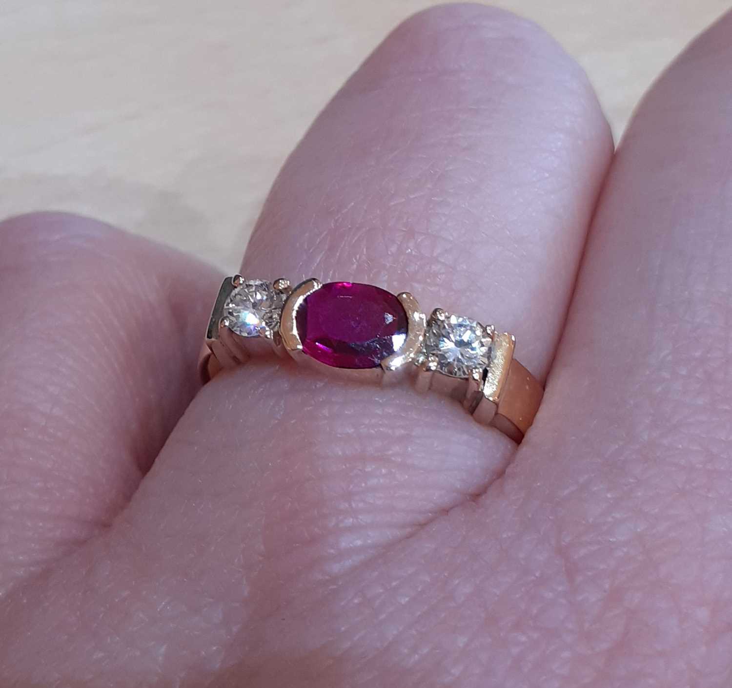 A Synthetic Ruby and Diamond Three Stone Ring the oval cut synthetic ruby in a yellow elongated claw - Image 4 of 5