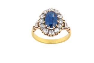A Sapphire and Diamond Cluster Ring the oval cut sapphire within a border of old cut diamonds, in