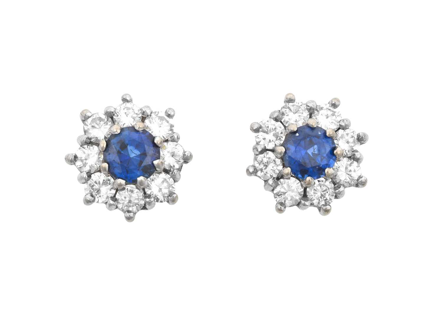 A Pair of 18 Carat White Gold Sapphire and Diamond Cluster Earrings the round cut sapphires within