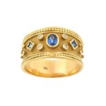 A Sapphire and Diamond Ring the oval cut sapphire flanked by a square cut sapphire to either side,