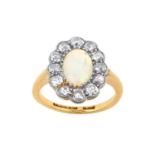 An Opal and Diamond Cluster Ring the oval opal within a border of old cut diamonds, in white