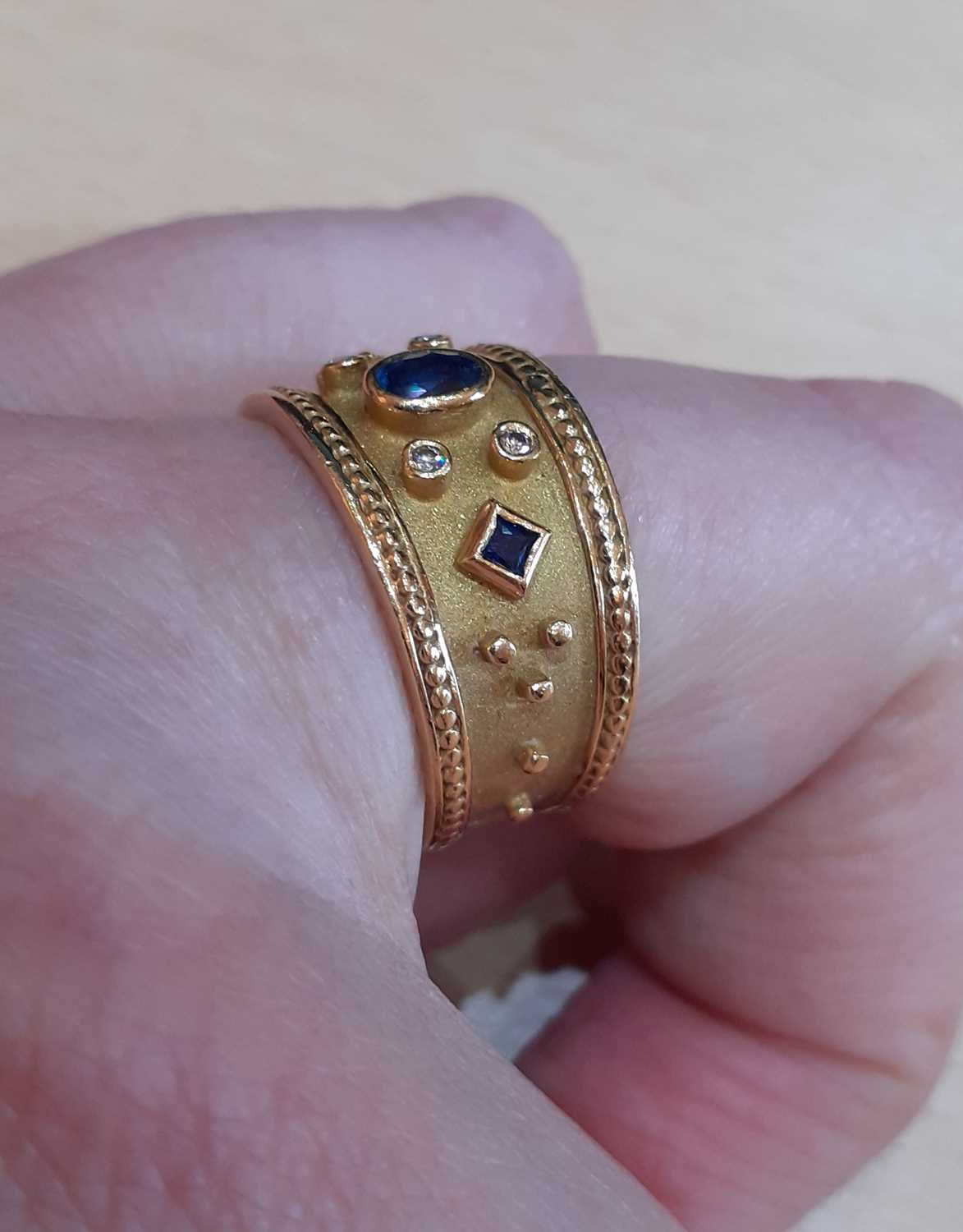 A Sapphire and Diamond Ring the oval cut sapphire flanked by a square cut sapphire to either side, - Image 4 of 6