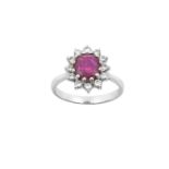 An 18 Carat White Gold Ruby and Diamond Cluster Ring the oval cut ruby within a border of round