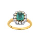 An Emerald and Diamond Cluster Ring the emerald-cut emerald in a yellow claw setting, within a