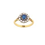 A Sapphire and Diamond Cluster Ring the round cut sapphire within a border of old cut diamonds, in