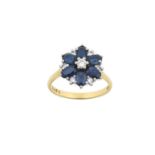 An 18 Carat Gold Sapphire and Diamond Cluster Ring the central raised round brilliant cut diamond