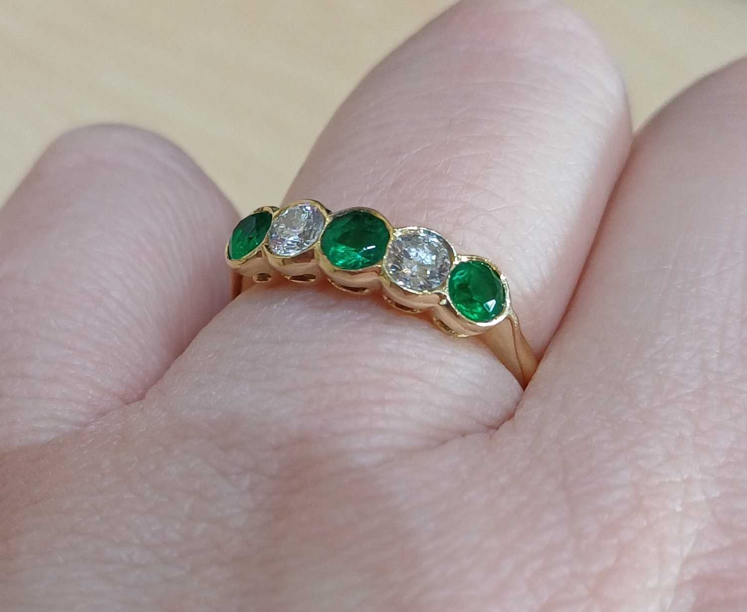 An 18 Carat Gold Emerald and Diamond Five Stone Ring three round cut emeralds alternate with two - Image 3 of 4