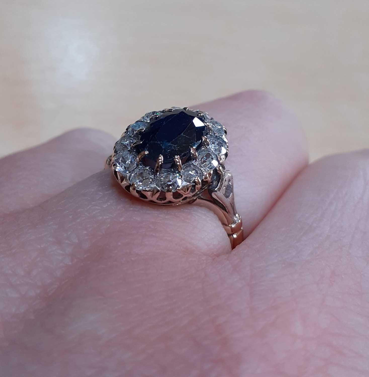 A Sapphire and Diamond Cluster Ring the oval cut sapphire within a border of old cut diamonds, in - Image 4 of 5