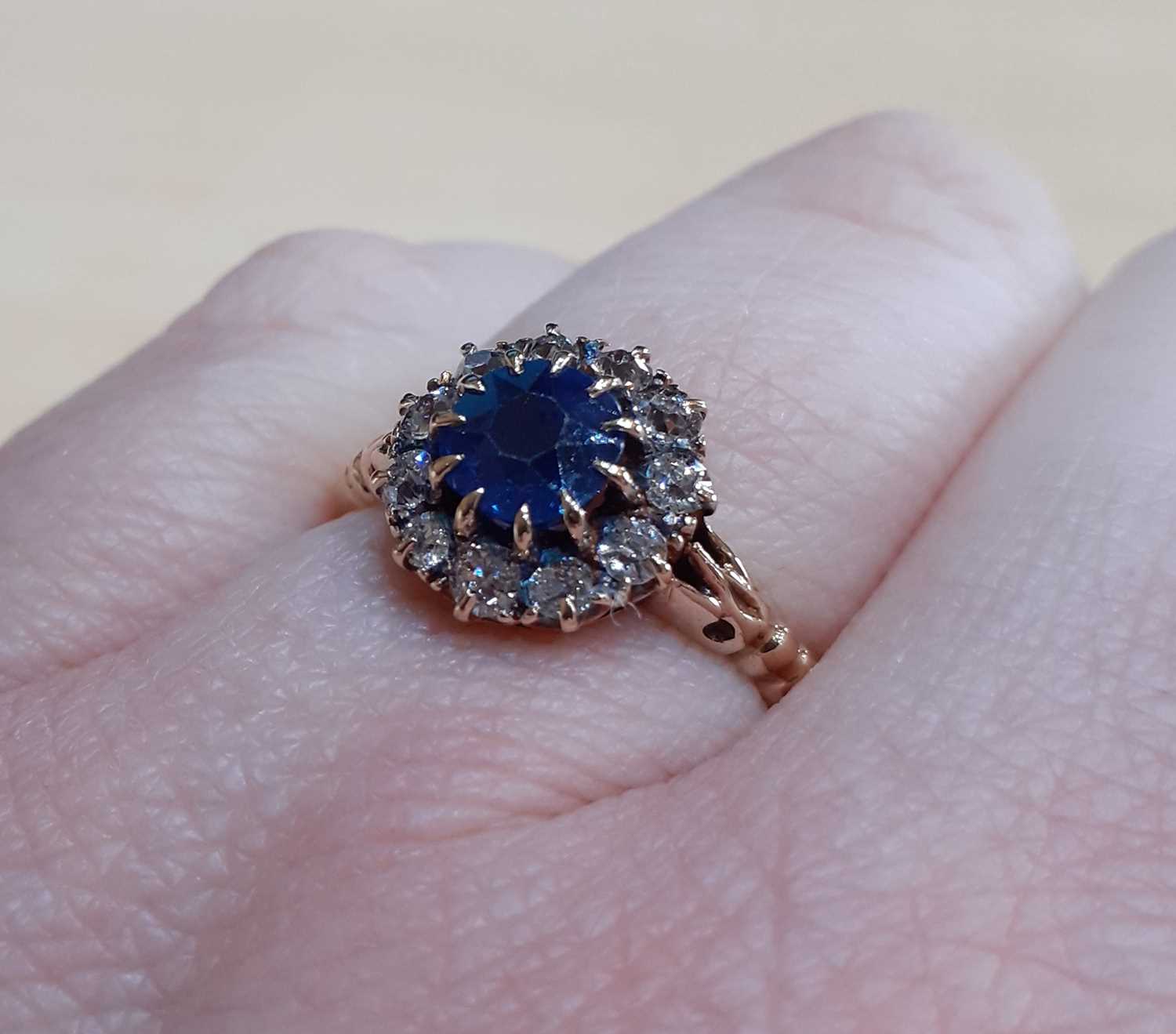 A Sapphire and Diamond Cluster Ring the round cut sapphire within a border of old cut diamonds, in - Image 4 of 4