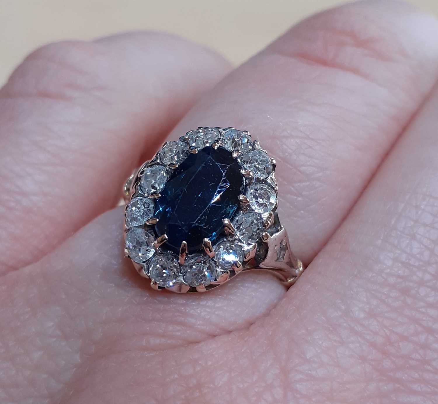 A Sapphire and Diamond Cluster Ring the oval cut sapphire within a border of old cut diamonds, in - Image 5 of 5