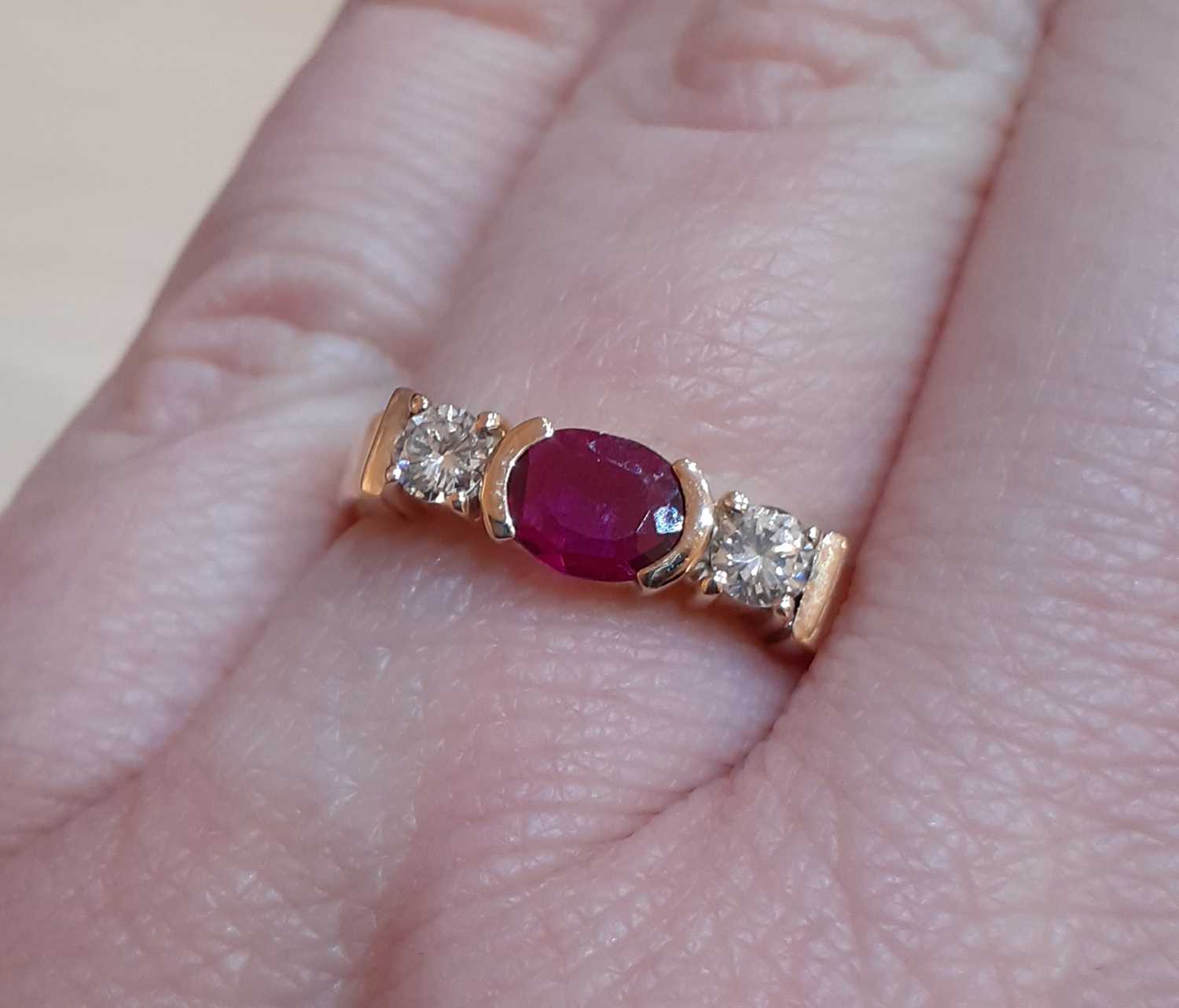A Synthetic Ruby and Diamond Three Stone Ring the oval cut synthetic ruby in a yellow elongated claw - Image 2 of 5