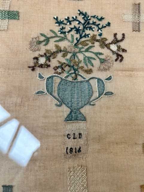 A 19th Century Darning Sampler, depicting a twin handled vase of flowers to the centre, with - Bild 3 aus 6