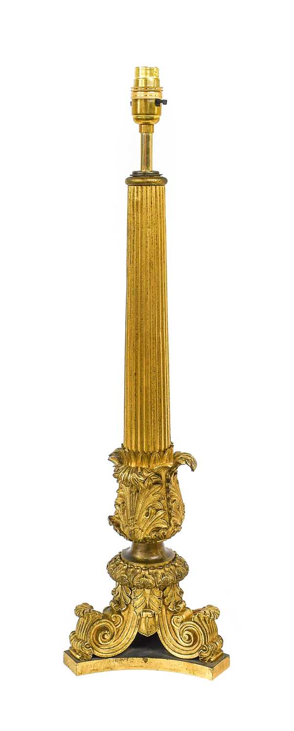 A Gilt Bronze Lamp Base, the fluted tapering column with basal acanthus sheathing, on a tricorn