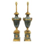 A Pair of Gilt and Green Marbled Metal Lamp Bases, in Louis XVI style, of urn form, the ram's mask