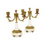 A Pair of Gilt Bronze and White Marble Twin-Light Candelabra, in Louis XVI style, with leaf-sheathed