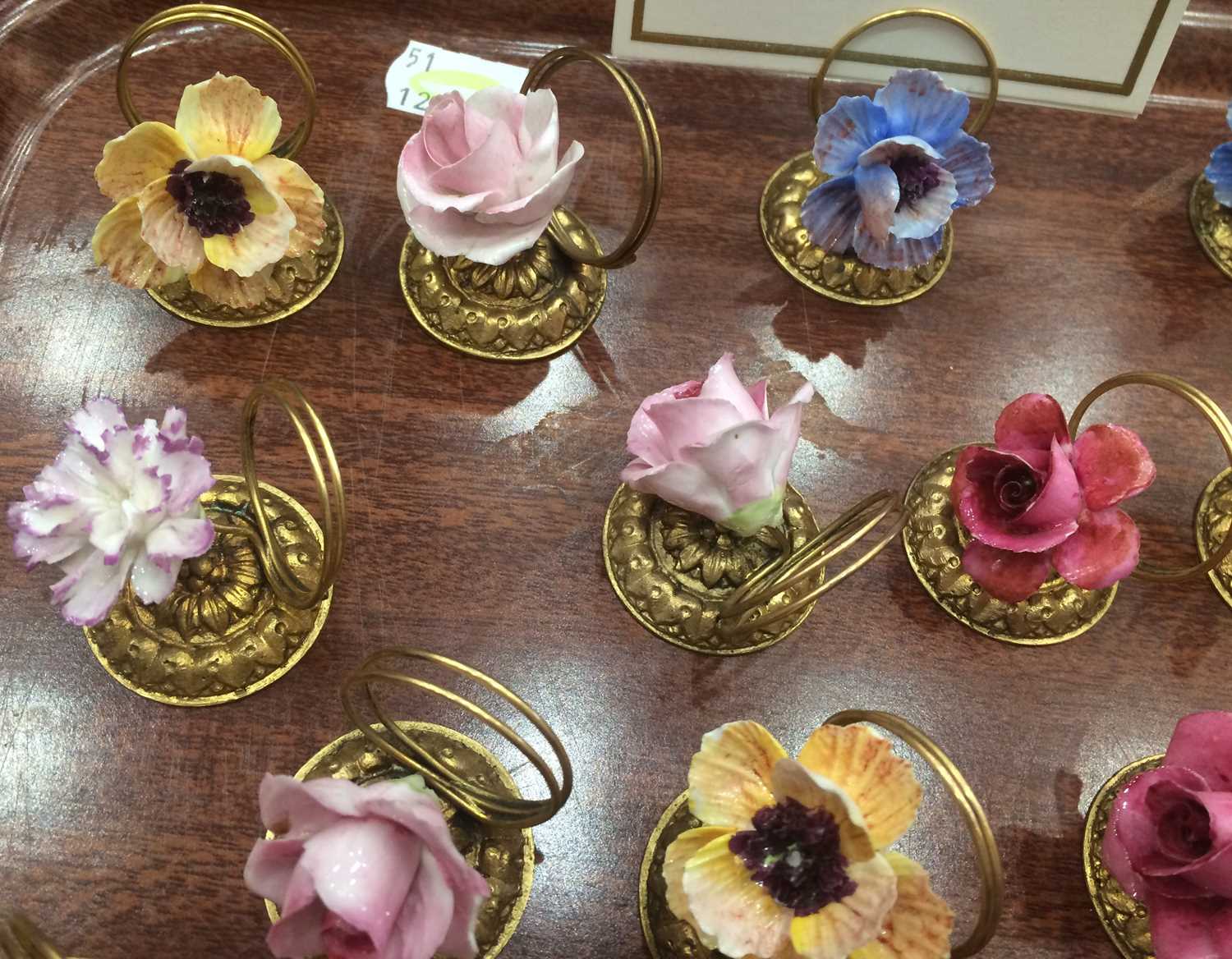 A Set of Fourteen Porcelain-Mounted Gilt Metal Place Card Holders, early 20th century, each with a - Image 4 of 5