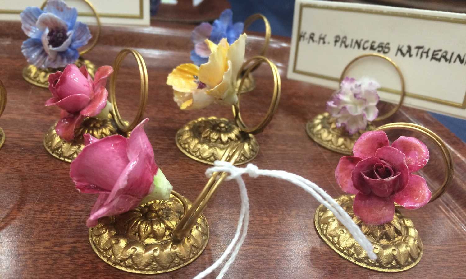 A Set of Fourteen Porcelain-Mounted Gilt Metal Place Card Holders, early 20th century, each with a - Image 2 of 5