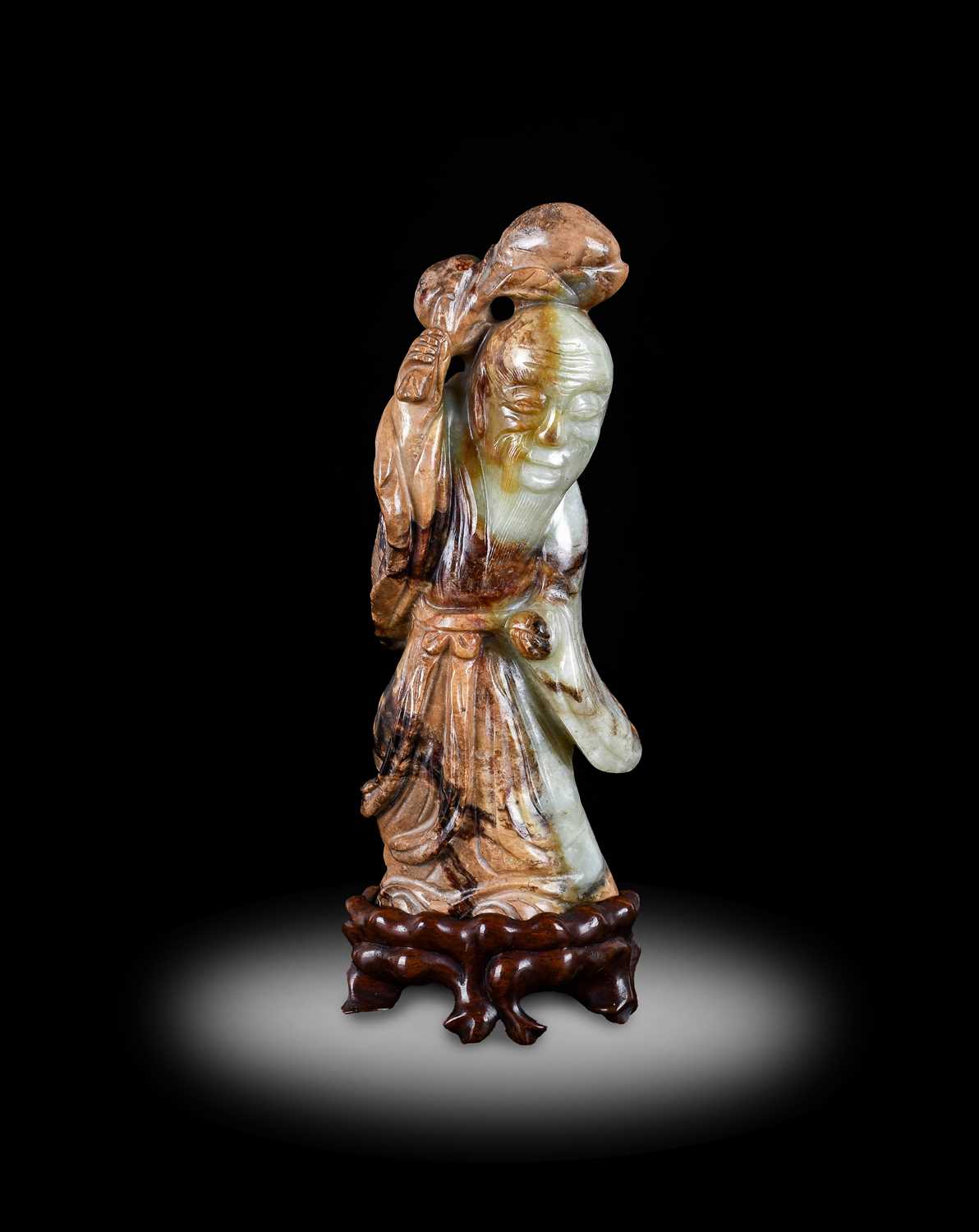 A Chinese Pale Celadon and Mottled Brown Jade Figure of Shoulao, in Ming style, probably late 18th/