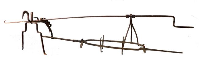 A Continental Wrought Andiron and Spit, 17th century, of scroll form and with five tiered spit rests