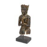 A South East Asian Lacquered Carved Wood Figure of a Divinty, in Kmer style, wearing scroll