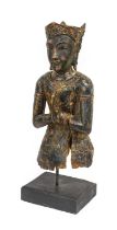 A South East Asian Lacquered Carved Wood Figure of a Divinty, in Kmer style, wearing scroll