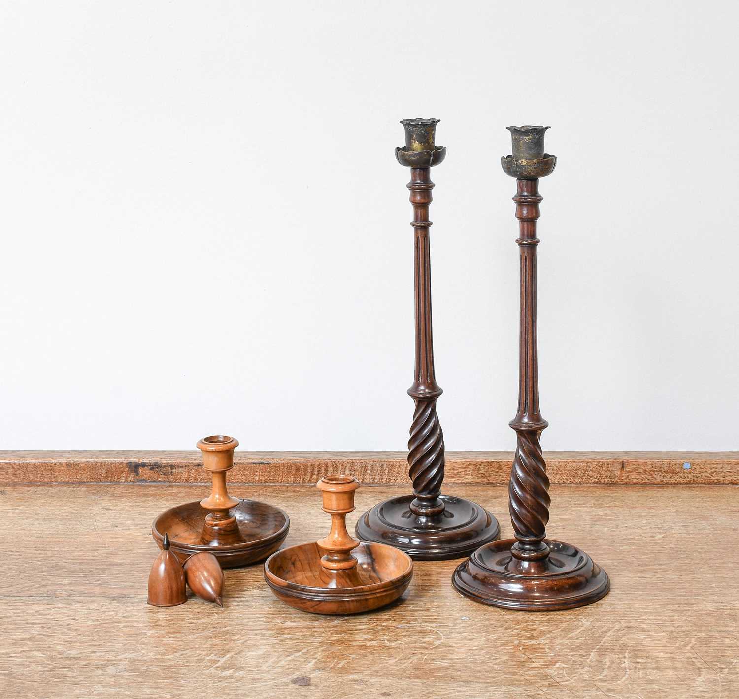 A Pair of George III Carved and Turned Mahogany Candlesticks, with brass petal formed sconces,