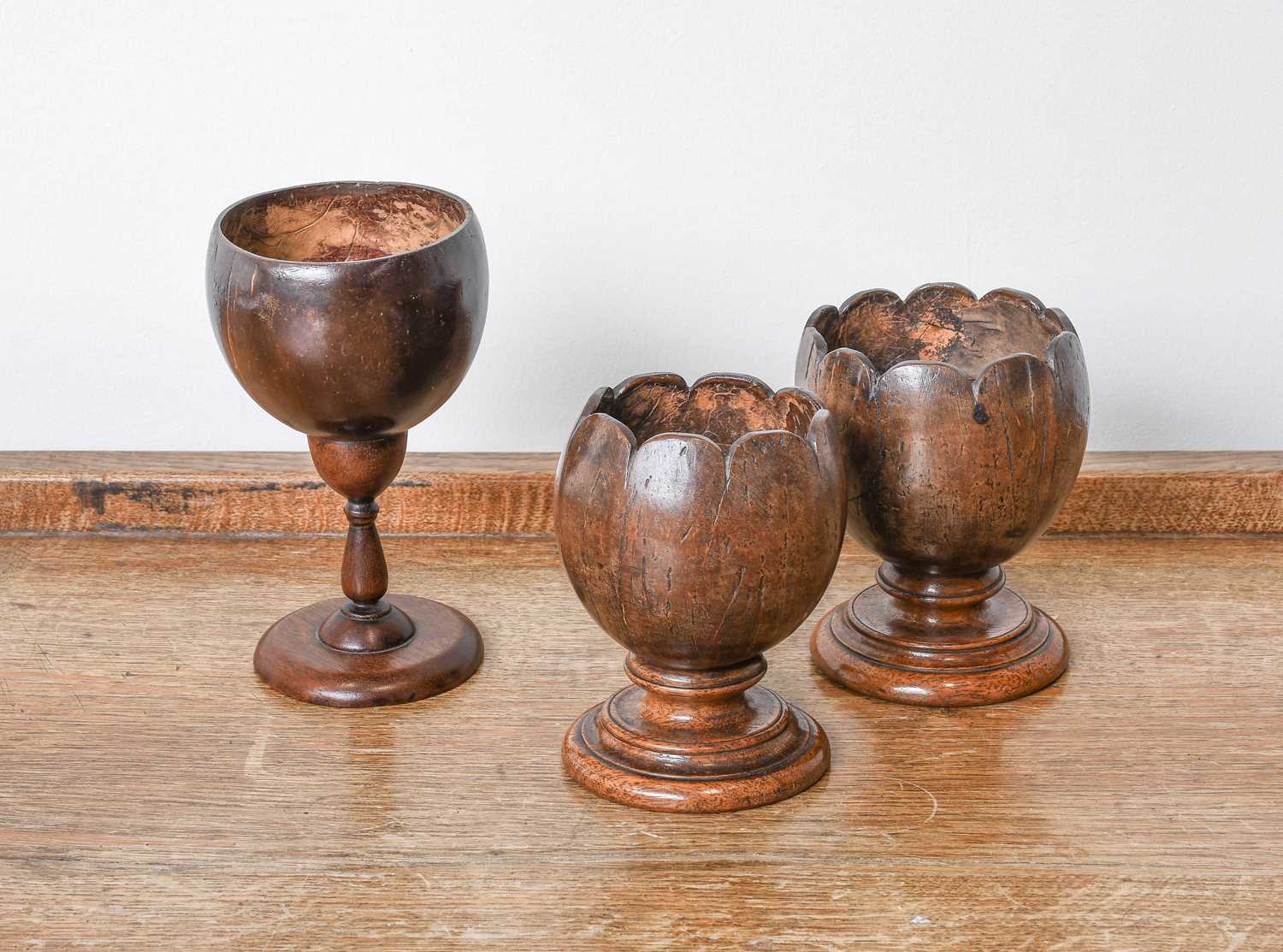 A Near Pair of Coconut Pedestal Bowls, 19th century, with lobed rims and on stepped circilar
