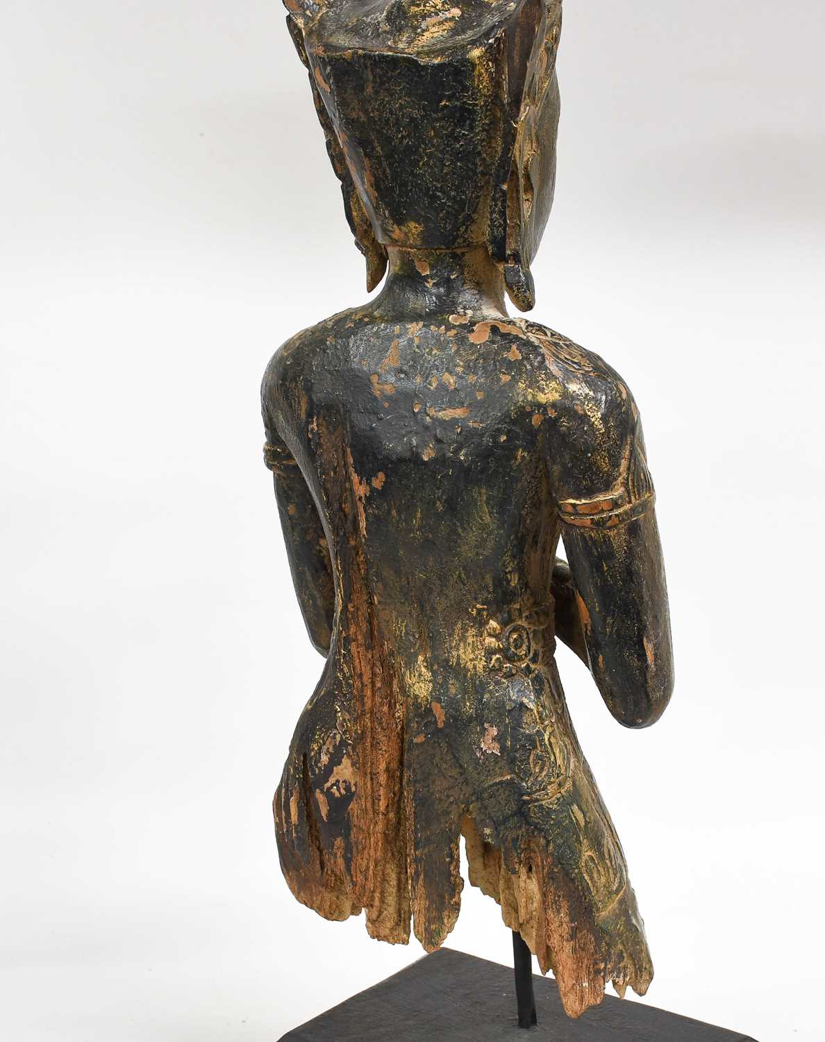 A South East Asian Lacquered Carved Wood Figure of a Divinty, in Kmer style, wearing scroll - Bild 2 aus 2